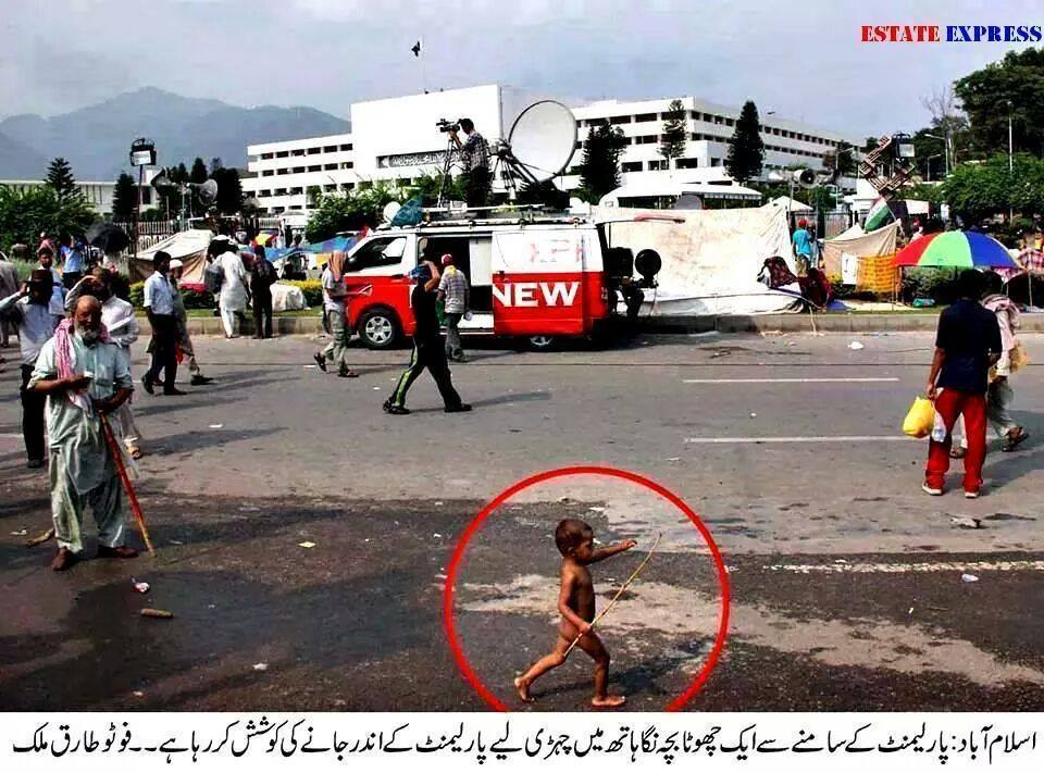 Naked small kid with stick in hand trying to enter parliament house